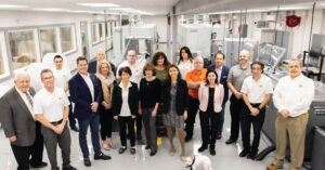 Team of Fort Orange Press employees standing in a manufacturing facility.
